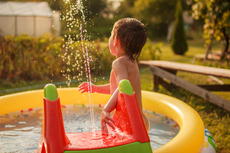 Happy child bathes in a pool. stream leading into the poolの写真素材