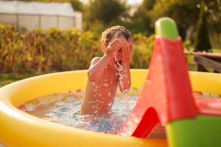 Happy child bathes in a poolの写真素材