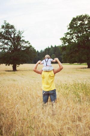 man walking with his kid in the fieldの写真素材