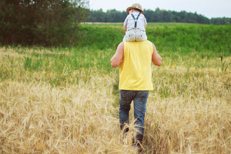 man walking with his kid in the fieldの写真素材