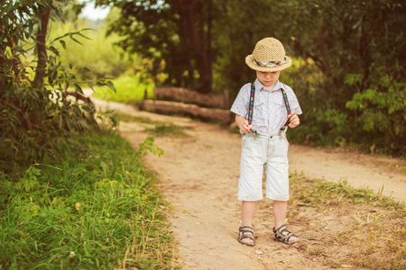 boy stands in the forest on footpathの写真素材