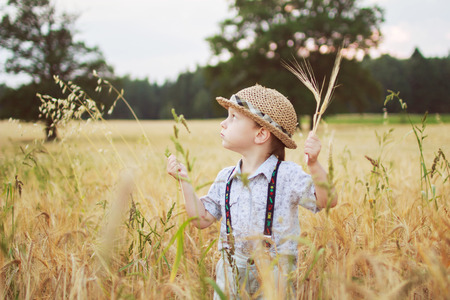 boy walking on a field of ryeの写真素材