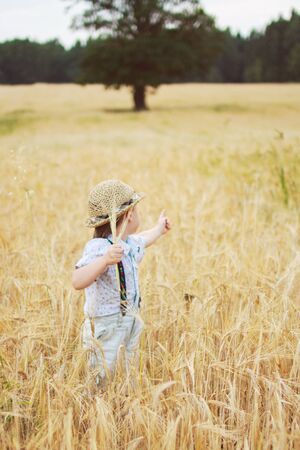 boy walking on a field of ryeの写真素材