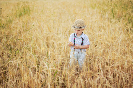 boy walking on a field of ryeの写真素材