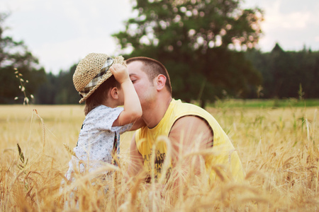 boy kiss his father in the fieldの写真素材