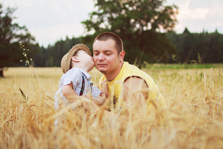 boy kiss his father in the fieldの写真素材