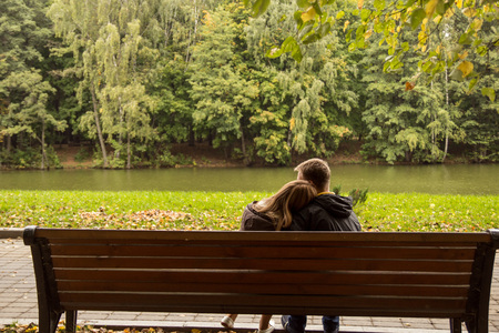 couple sitting on a bench and huggingの写真素材