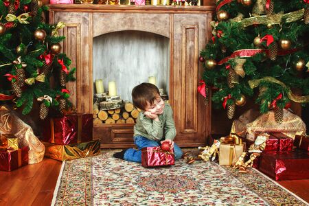 child sitting under the Christmas tree with giftsの写真素材