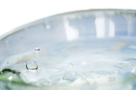 Water drips into the bowl with splashesの写真素材