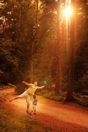Dad and son walking in the forest at sunset. happy family outdoor.の写真素材