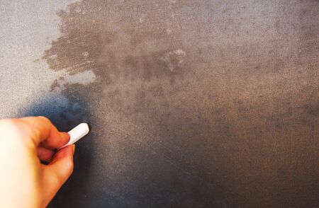 chalk board and hand with chalk. person writes on the chalkboardの写真素材