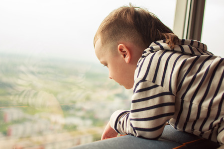 boy looks out the windowの写真素材