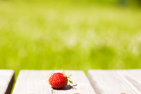 Strawberries on a wooden background. Strawberry against the background of the green grassの写真素材