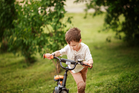 the boy is riding a bike on the streetの写真素材