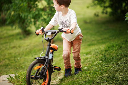 the boy is riding a bike on the streetの写真素材