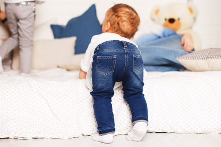  the child crawls out of bed. child near the bedの写真素材