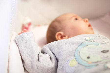 newborn baby lies in the little cradle. hand of a newbornの写真素材