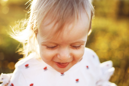 portrait of a little happy girl outdoor . the child smiles and shows the tongueの写真素材