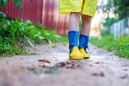 child in rubber boots walking outdoor. child's feet in a rubber bootの写真素材