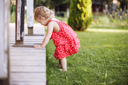little girl playing alone in the gardenの写真素材