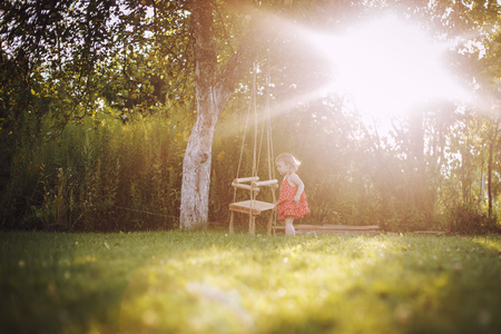 girl in the garden playing with swings.  baby playing in the gardenの写真素材