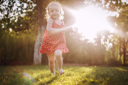 happy baby smiling.  little girl running  at sunsetの写真素材