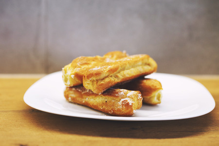 eclairs cakes lie on a white plate.  sweet cakes eclairs
