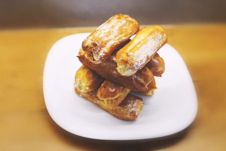 eclairs cakes lie on a white plate.  sweet cakes eclairs