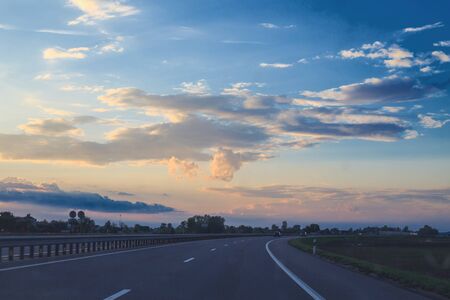 road on a background of clouds in the form of a heart on the sunset sky
