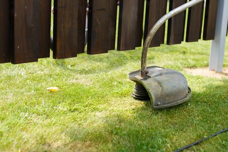 a man mows grass with a trimmer outdoorの写真素材