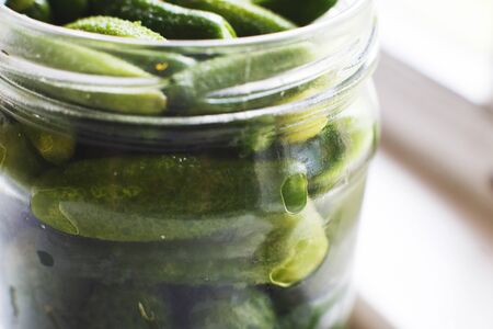 glass jar  with a pickled cucumbers. gherkins cucumbers  background.の写真素材