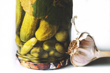 pickled cucumbers in a glass jar on a white background.  inverted jar with cucumbers.の写真素材