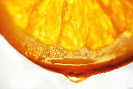 orange slice with a drop of water close up on a white backgroundの写真素材