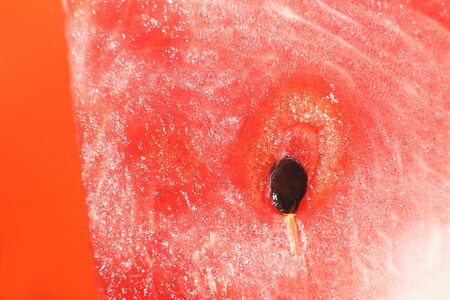 slice of watermelon on orange background close-up. watermelon seed macroの写真素材