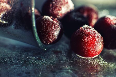 closeup frozen cherry in the glass with reflection . frozen cherry  on a dark background macroの写真素材