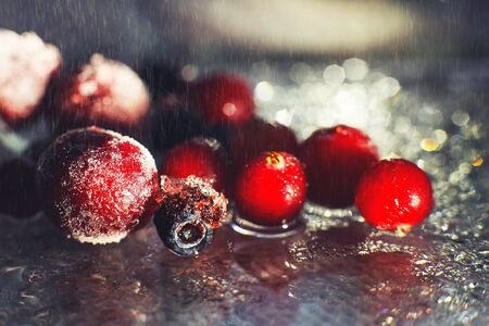 closeup frozen berries on the glass with reflection . frozen berries  on a dark background macro. cranberries blueberries and cherries の写真素材