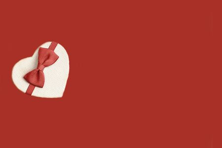 gift boxes in the form of a heart with a red bow on a red background. place for your textの写真素材