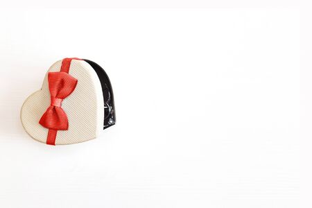 gift box in the form of a heart with a red bow on a white background. place for your textの写真素材