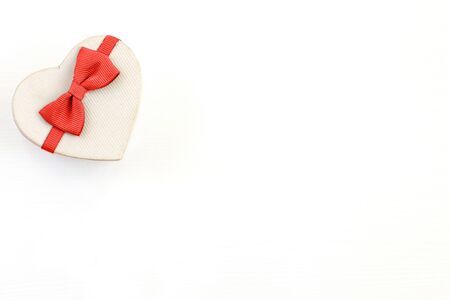 gift box in the form of a heart with a red bow on a white background. place for your textの写真素材