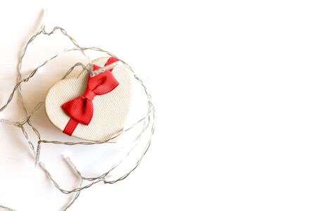 gift box in the form of a heart with a red bow on a white background. place for your textの写真素材