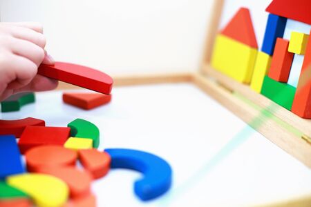 child plays wooden magnetic educational game. child plays with a toy on a white background.の写真素材