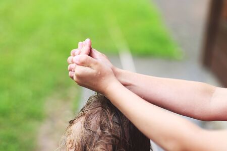 brother and sister play in rainy weather. wet hands close.