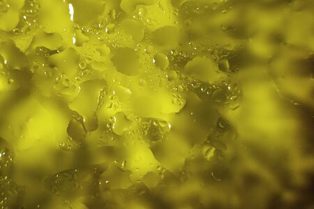 water drops on a yellow background. Abstract yellow background. Water drops on glass.の写真素材