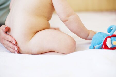 Mother and baby. Mom's love and tenderness. Mother massaging baby in the bed at homeの写真素材