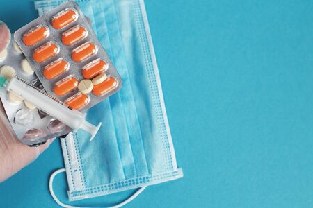 medical mask, syringe and tablets close on the blue background. Coronavirus, flu, respiratory disease concept. Horizontal orientation. Top view.の写真素材