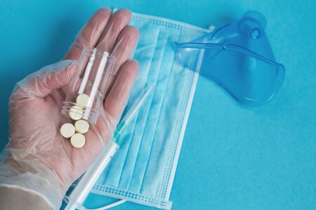 medical mask, syringe and tablets close on the blue background. Coronavirus, flu, respiratory disease concept. Horizontal orientation. Top view.の写真素材