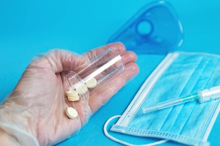 medical mask, syringe and tablets close on the blue background. Coronavirus, flu, respiratory disease concept. Horizontal orientation. Top view.の写真素材
