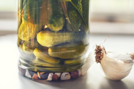 pickled cucumbers in the glass jar on a white background. inverted jar with cucumbers.の写真素材