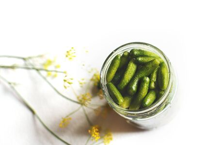 a jar with pickled cucumbers on a white background. gherkins cucumbers.の写真素材