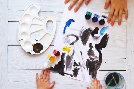 view from above. child draws a brush and paints top view. Flat lay art tools for painting.の写真素材